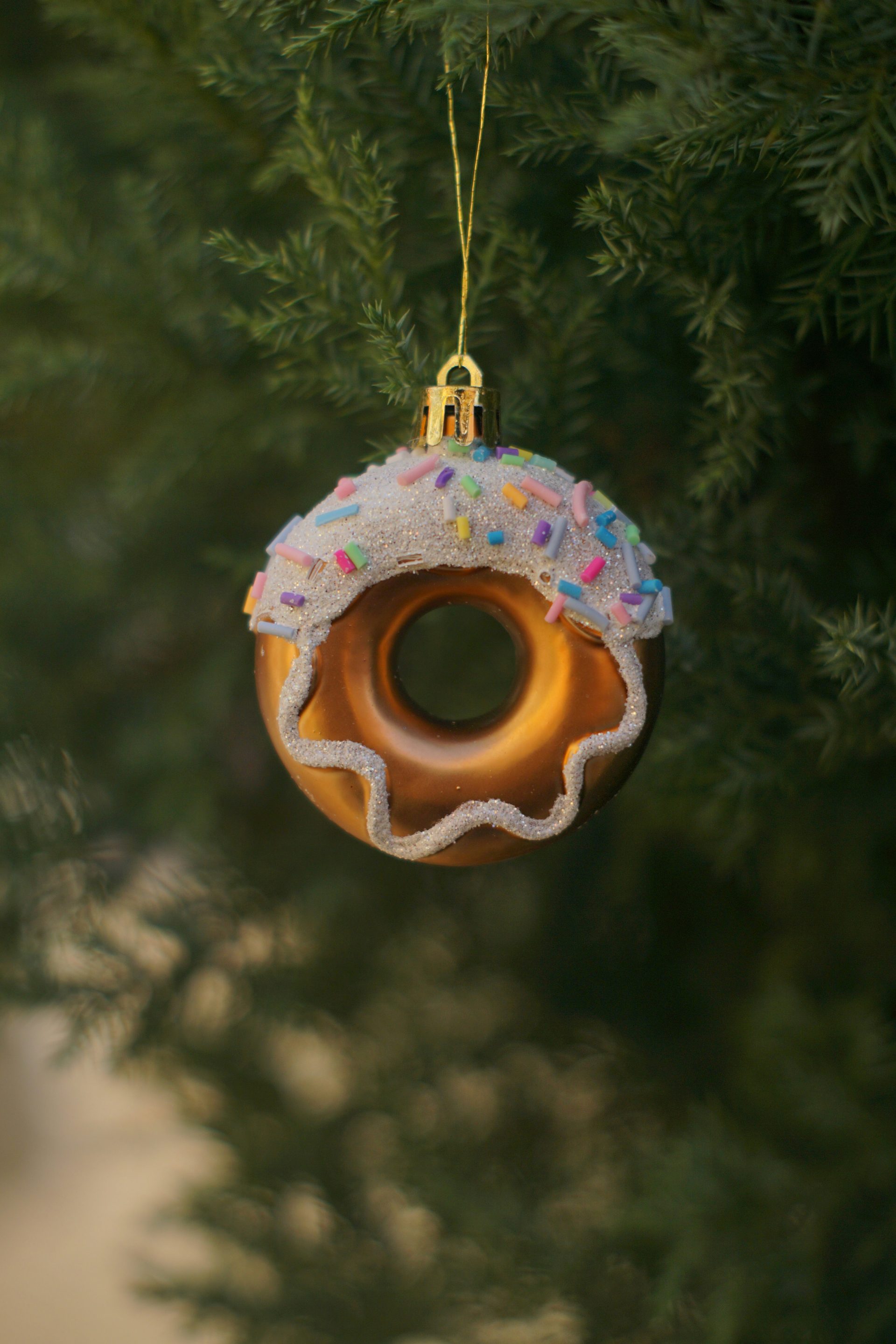 Donut-Ornament, das an einem Weihnachtsbaum hängt.